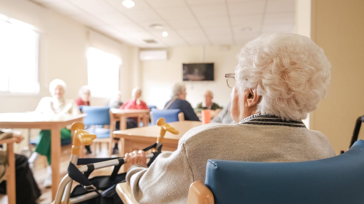 A senior woman sitting with her walker in the company of friends